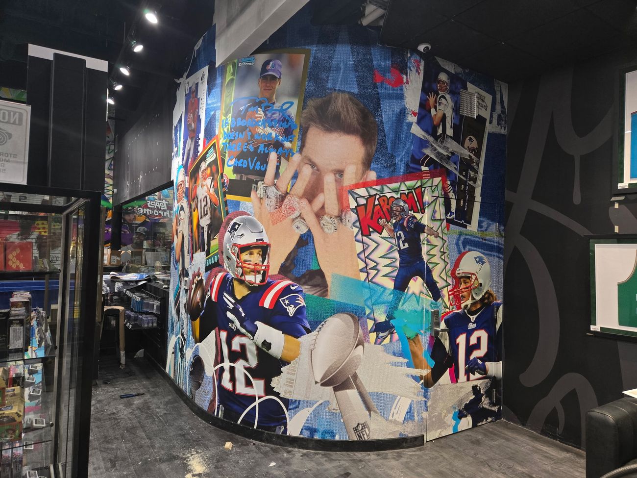 Curved wall mid-install showing the Brady mural following the radius