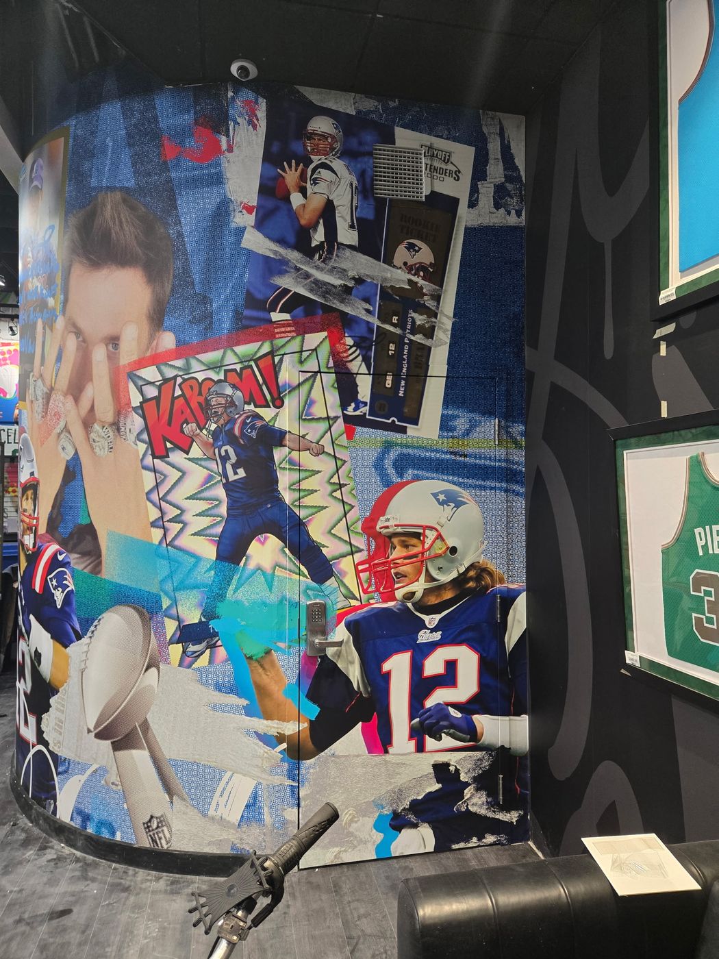 Curved interior column wrapped in a Tom Brady comic-style mural at CardVault by Tom Brady